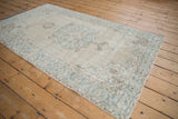 Distressed ivory and pale blue vintage Sparta rug, corner spandrel, vinery, and worn pile.
