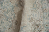 Folded vintage distressed Sparta rug showcasing faded blue vinery and a clean, hand-knotted reverse.