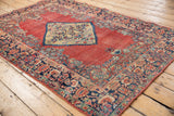 Vintage Persian Arak rug: abrashed brick red field, ivory floral medallion, navy floral vine border.