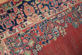 Vintage Arak rug's abrashed brick red field with foundation showing through to navy floral border.