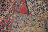 Folded Vintage Arak rug corner displays detailed hand-knotted foundation and brick red selvage.