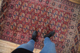 Vintage Turkmen rug's chestnut and magenta guls, with visible textured pile and abrashes.