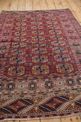 Vintage Turkmen rug displaying geometric elephant footprint guls and intricate multi-layered borders.