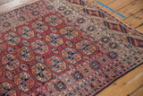 Elephant footprint guls in navy, fuschia, and gold on a rust field, with patterned borders.