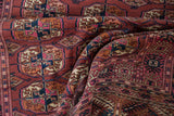 Vintage Turkmen rug showcasing geometric guls and intricate borders in rich magenta, navy, and chestnut.