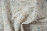 Distressed vintage Sparta rug showing textured pile with ivory, blue, and beige scrolling vinery.