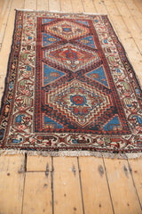 Vintage Hamadan rug corner, displaying stepped contour and hook-and-latch borders in indigo, ivory, red.