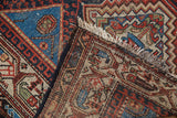 Vintage Hamadan rug's hand-knotted foundation, white fringe, indigo, red, ivory patterns.