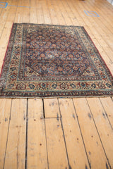 Corner detail of vintage Malayer rug, showing ivory, navy, and red Herati pattern.