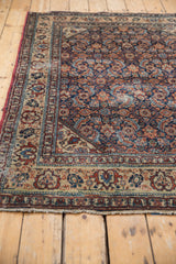 Malayer rug corner, Herati motif with navy, wine, ivory hues, and storied texture.
