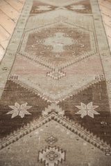 Vintage Distressed Oushak runner's starburst design in faded ivory, mauve, and coffee brown tones.