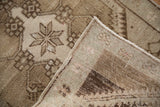 Vintage distressed Oushak rug: starburst motifs, low pile, and hand-knotted reverse in browns and subtle mauve.