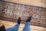 Distressed vintage Kaisery runner section with allover Herati motif, ivory ground, and red border.