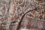 Folded vintage Kaisery runner detail, distressed Herati pattern on ivory with visible knot heads.
