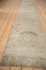 Vintage distressed Oushak runner texture, even wear and abrashed beige, pale copper medallion.