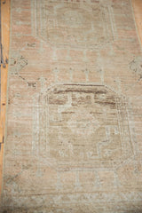 Distressed vintage Oushak runner with even wear, subtle medallion, and soft beige tones.