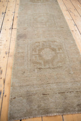 Distressed vintage Oushak rug runner end showing even wear to knot heads and faint foundation.