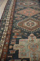 Angled view of the low pile and geometric motifs on a vintage Persian Karaja runner.