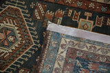 A folded corner of the vintage Karaja rug showing its dense hand-knotted back and side selvage.