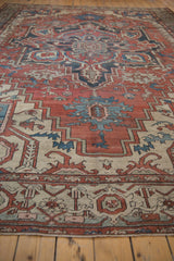 Detail of distressed Vintage Serapi carpet, showcasing Samovar turtle border motifs in rust, ivory, and blue.