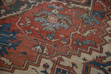 Distressed Serapi carpet detail: rust, blue, beige geometric serrated motifs, soft wear.