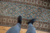 Distressed geometric dusty blue field and crab border of vintage Caucasian runner underfoot.