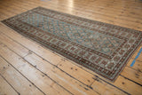 Side view of distressed Caucasian runner, highlighting crab border, geometric floral field, even pile wear.