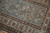 Distressed vintage Caucasian runner featuring a geometric floral field and crab border with dusty blue and faded raspberry.
