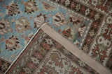 Distressed Caucasian runner, folded corner showing hand-knotted pile and secured edge.