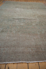 Distressed vintage Bijar carpet end with muted terracotta, teal colors, and even pile wear.