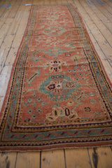 Textured pile of a distressed vintage Oushak runner with ruby red and pale blue floral motifs.