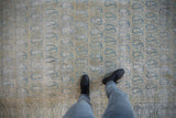 Distressed vintage Meshed carpet with pale blue paisley motifs and visible foundation wear.