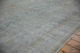 Distressed vintage Persian Meshed carpet, showing faded blue boteh paisley and worn foundation.