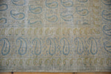 Worn pile of a distressed Meshed carpet, showing faded blue boteh and exposed foundation.