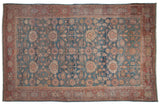 Distressed Persian Mahal carpet with faded blue floral palmettes and red border.