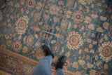 Vintage Distressed Mahal carpet: denim blue field, blush palmettes, textured wear, with black boots.