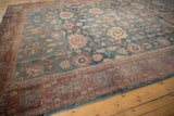 Textured border detail of a distressed Mahal rug with denim blue and brick red hues.