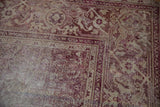Distressed Amritsar rug corner, worn Mahi Mahi Herati pattern, dusty raspberry, and beige.