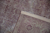 Distressed dusty raspberry antique Amritsar rug pile with visible foundation and woven reverse.