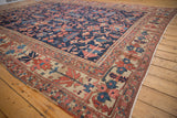 Antique Heriz carpet's border showing large-scale primitive red, blue, and ivory motifs.