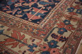 Antique Heriz rug's navy, brick red, ivory pile with primitive field and border motifs.