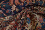 Folded antique Heriz rug detail, large primitive design in navy, brick red, ivory, and worn pile.