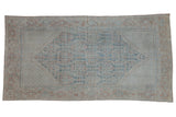 Distressed vintage Mahal carpet, muted dusty teal, brick red, and beige starburst patterns.