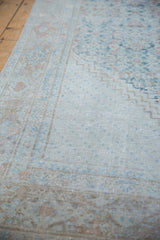 Distressed Mahal carpet's worn texture with faded dusty teal, beige, and blush patterns.