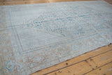 Distressed vintage Mahal carpet corner, displaying geometric vinery in soft dusty teal and beige.