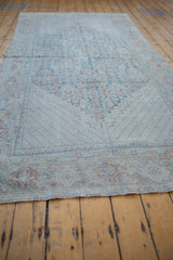 Distressed pile detail of a vintage Mahal rug, showing muted dusty teal and brick red vinery.