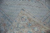 Distressed vintage Mahal rug with folded corner, highlighting mostly even wear and subtle teal motifs.