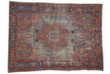 Antique Heriz rug with oversized geometric medallion, palmettes, sky blue, cherry red, navy, and storied wear.