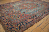 Antique Heriz carpet medallion, geometric field motifs, sky blue, dusty red, with visible wear.