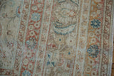 Distressed Meshed carpet edge, showcasing worn pile, subtle blue and terracotta tones, plus fringe.